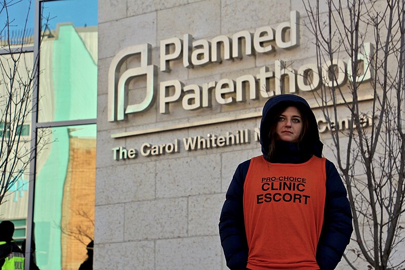 A_clinic_escort_outside_the_Planned_Parenthood_-_Carol_Whitehill_Moses_Center_(38949360565)