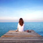 girl-sitting-alone-wooden-bridge-sea-frustrated-depression_335224-1019
